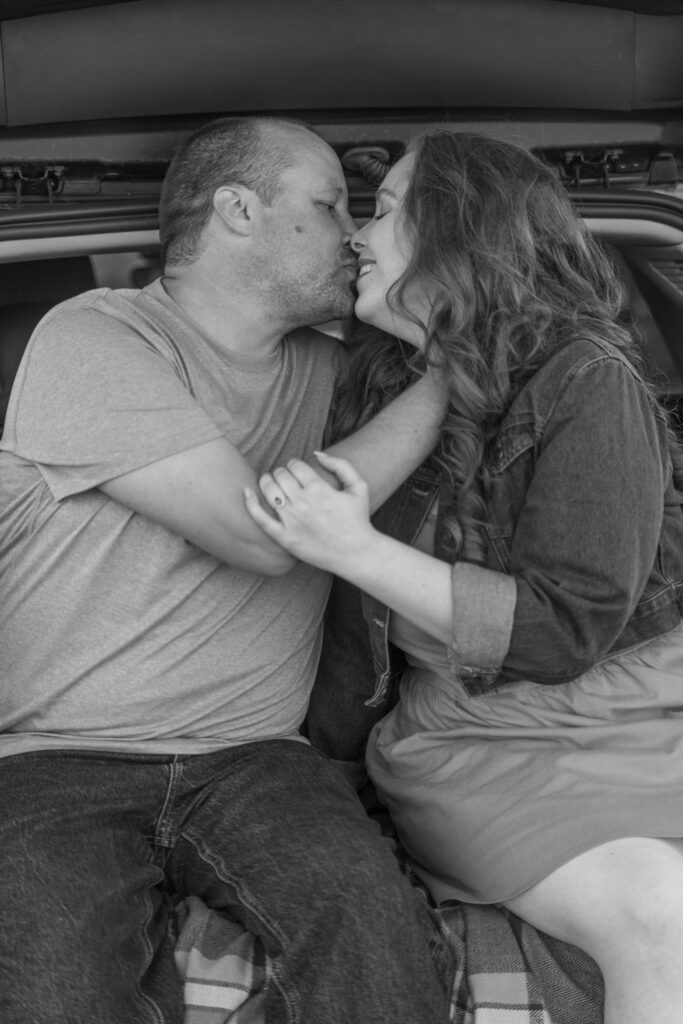 Couple kissing at the back of the car